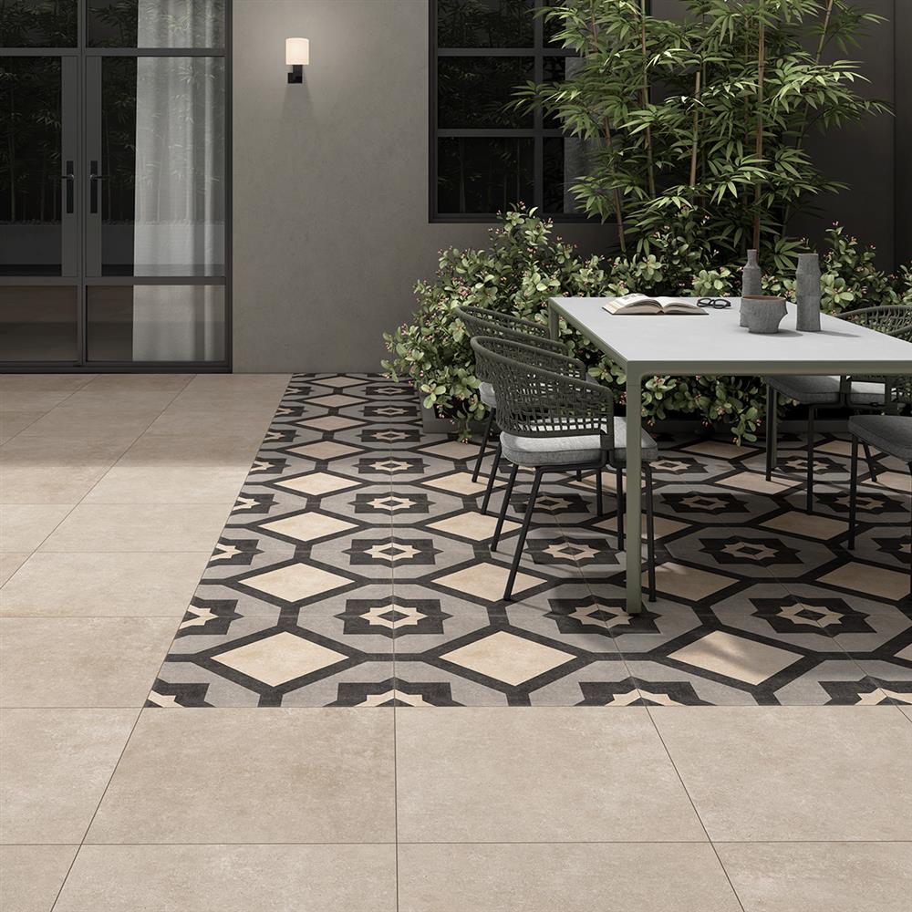 Patterned outdoor paving tiles with plain matching tiles surrounding a seating area